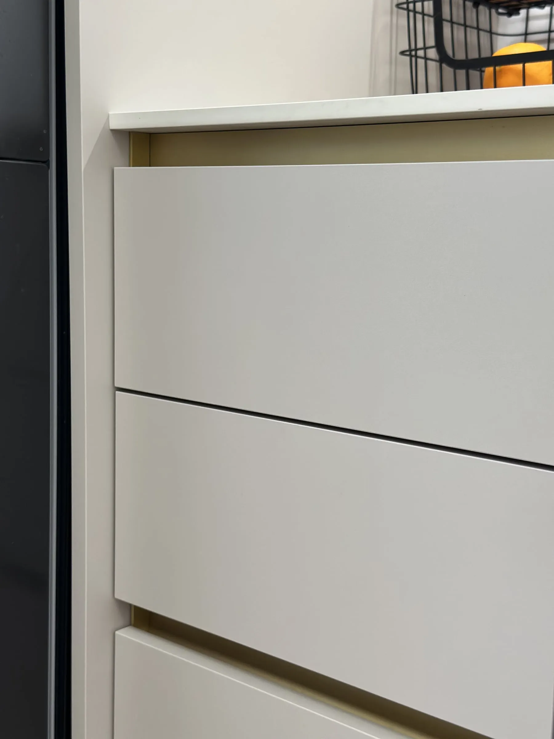 Detail: zlatý profil na uchopenie pod frontom zásuvky