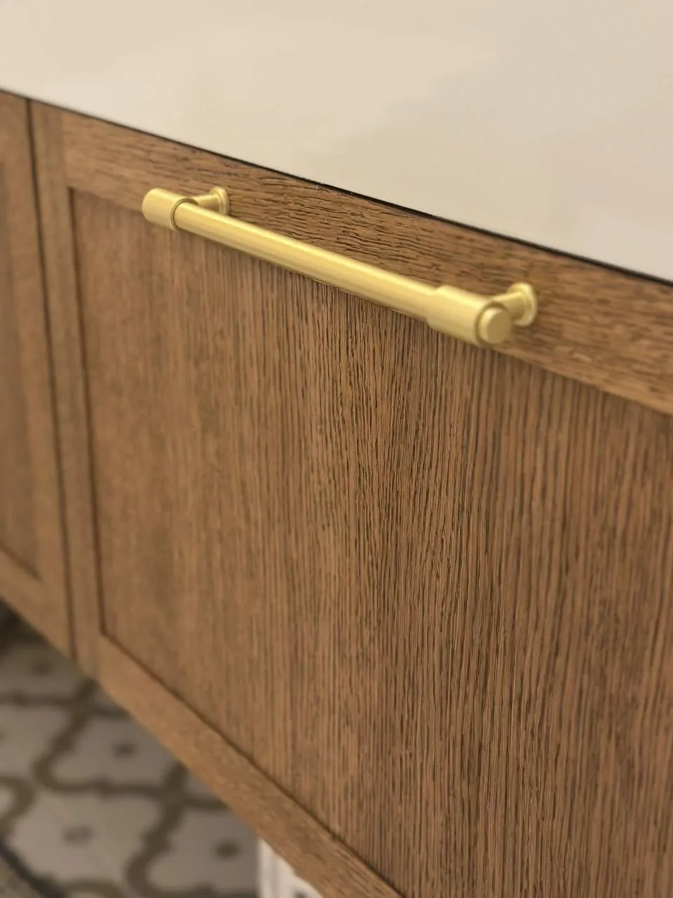 Detail: dlhá zlatá úchytka na rámovom fronte v dreve