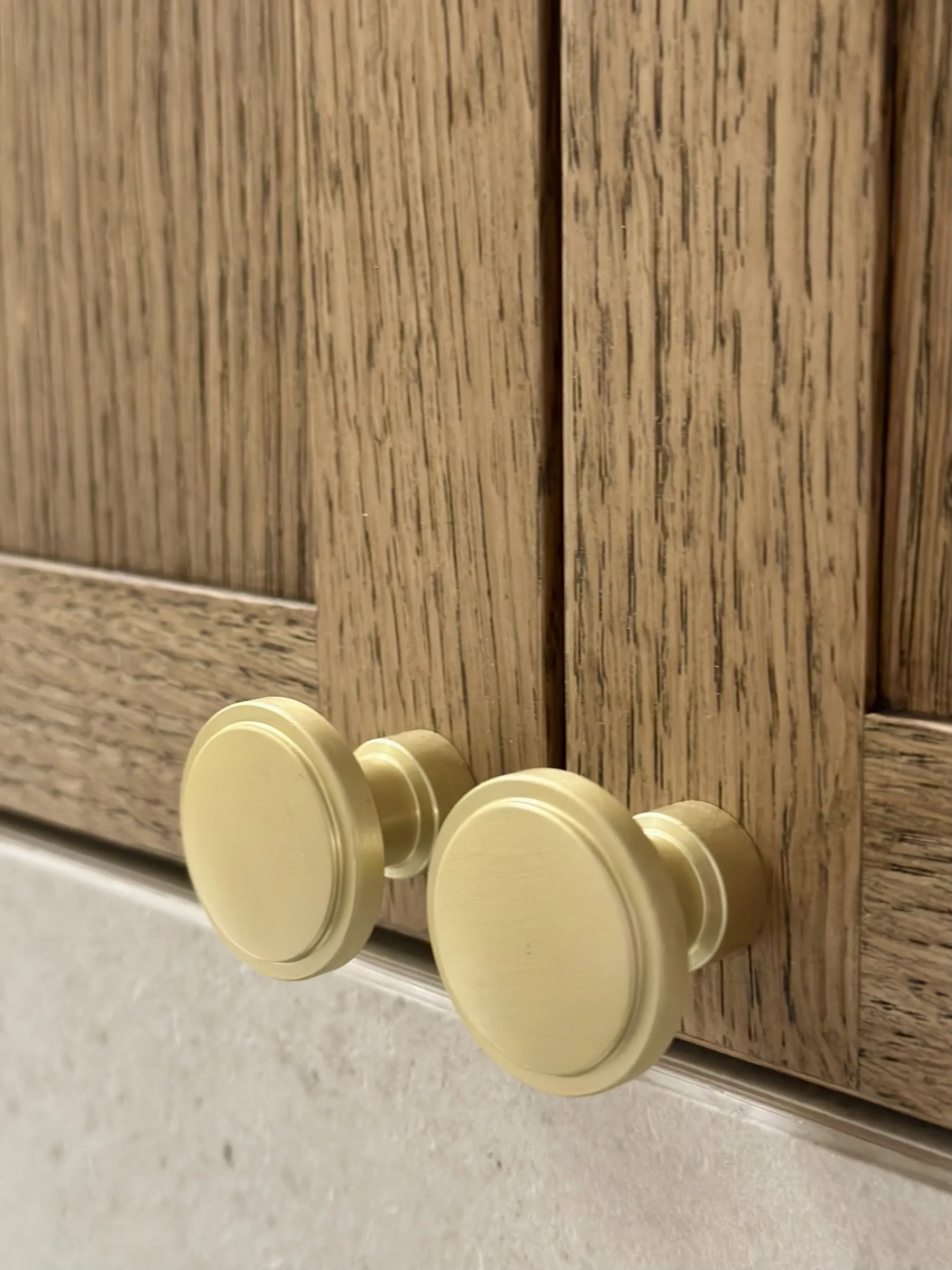 Detail: dve okrúhle zlaté úchytky na rámových dvierkach
