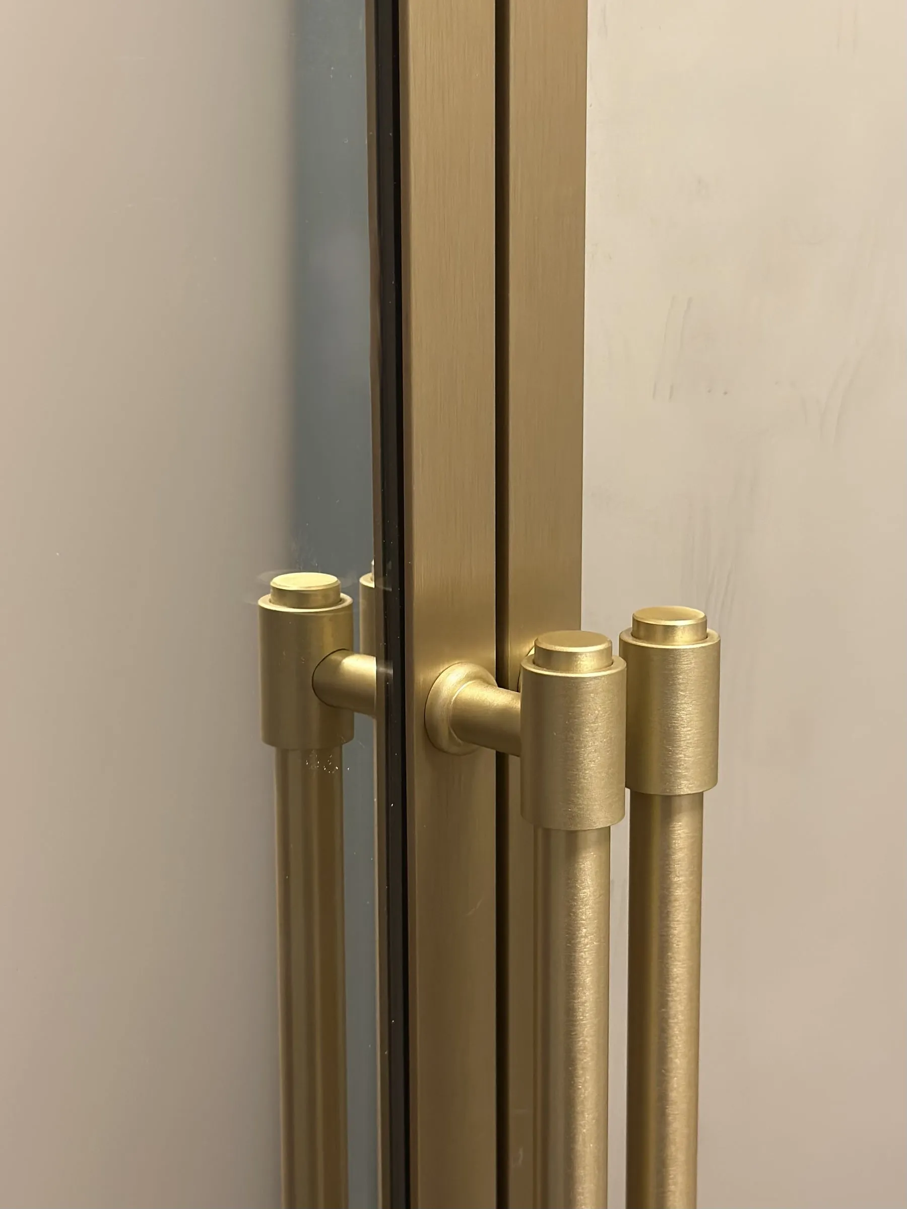 Detail: zlaté úchytky na zrkadlových dvierkach skrine